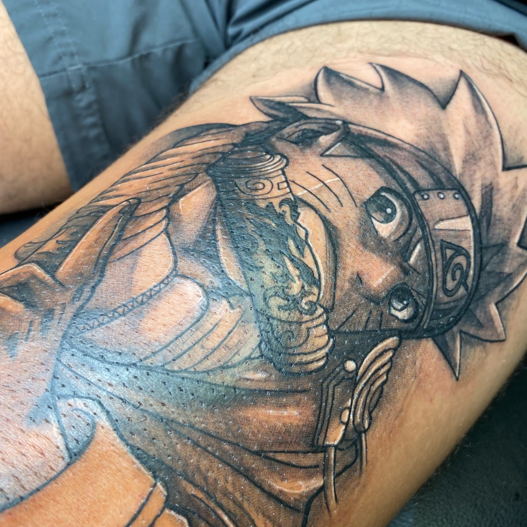 Detailed Naruto tattoo featuring bold lines and black and grey shading